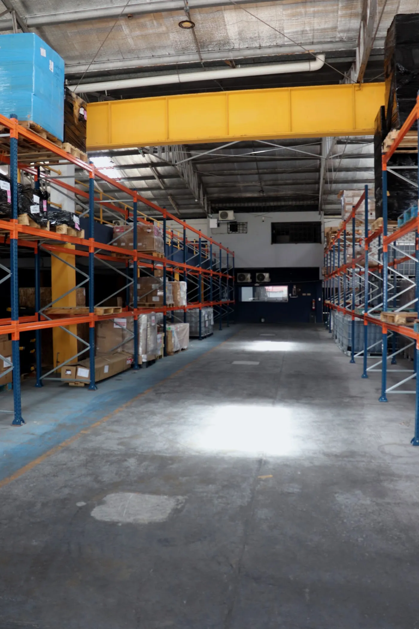 Pasillo central de la bodega con racks selectivos ocupados