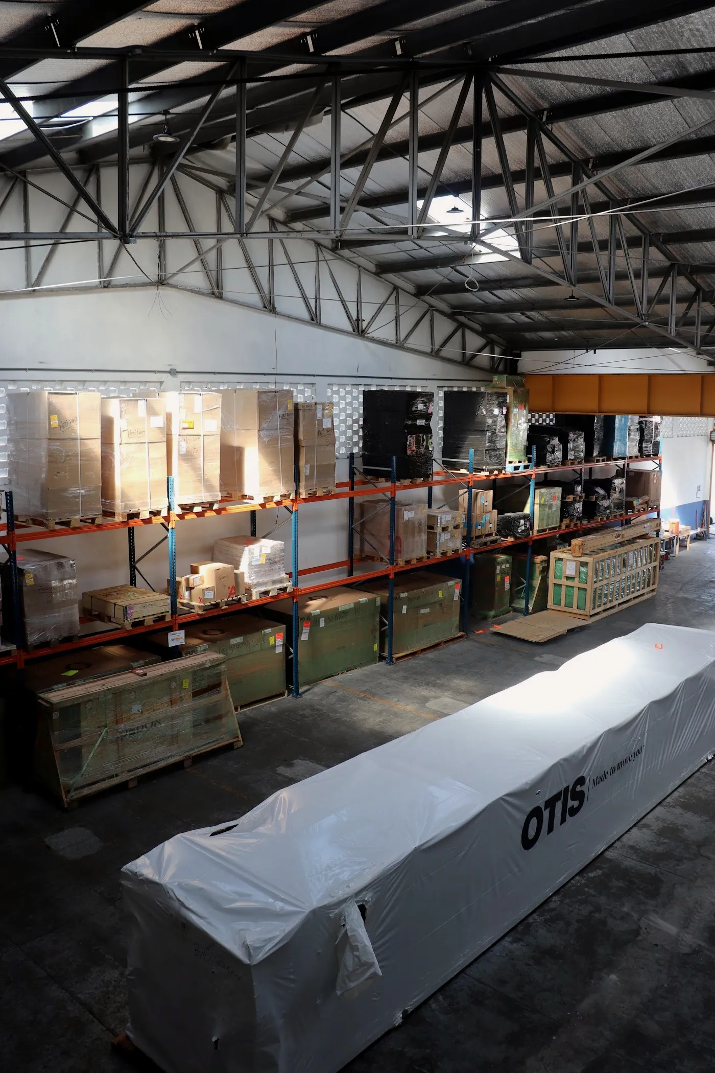 Vista elevada de la nave con racks ocupados y equipo de manejo